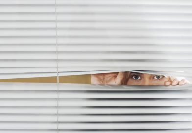 Woman Looking Through Venetian Blinds