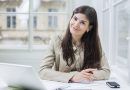 Portrait of confident businesswoman with laptop sitting at office desk